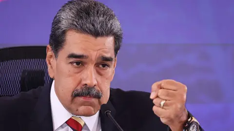 Getty Images President of Venezuela Nicolás Maduro holds a fist up and speaks during a press conference at Hotel Melia Caracas 